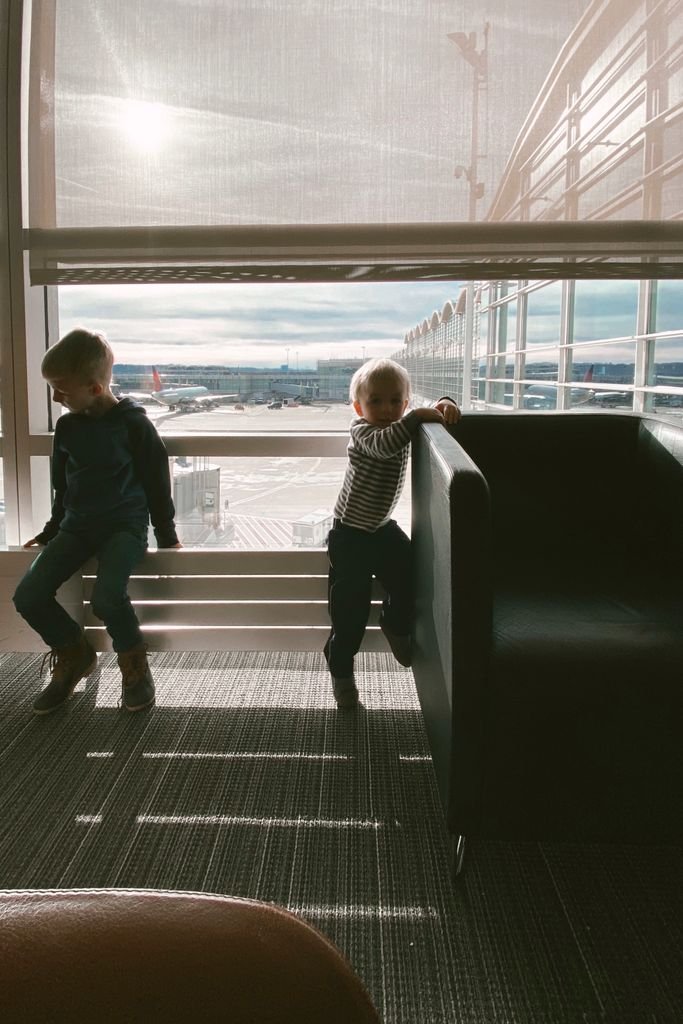 acumular mas puntos viajando en familia - niños mirando aviones en el aeropuerto