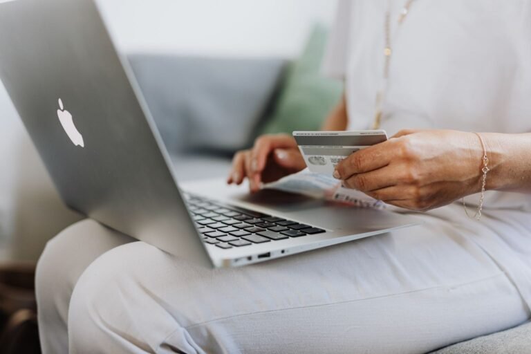 Persona pagando un viaje en su laptop con una tarjeta afiliada a aerolínea