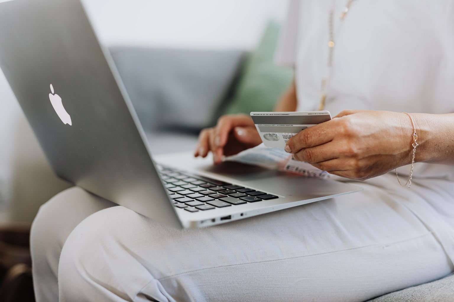 Persona pagando un viaje en su laptop con una tarjeta afiliada a aerolínea