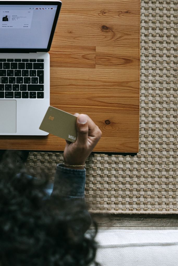 Persona reservando un vuelo online con su tarjeta afiliada a aerolínea en la laptop