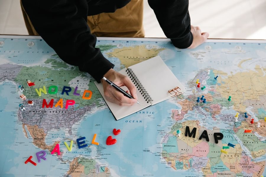 Persona planeando su viaje sobre un mapa mundial antes de buscar vuelos baratos con inteligencia artificial