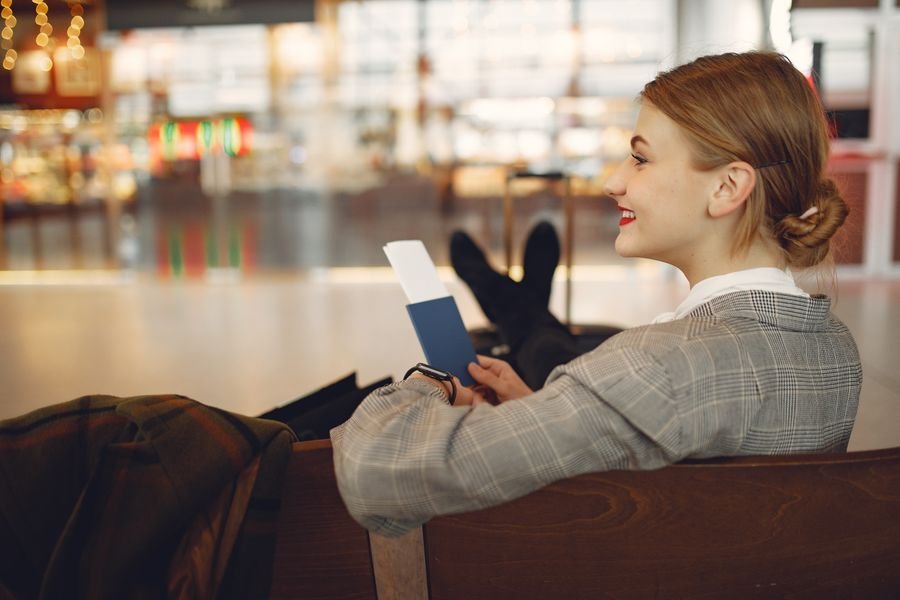 Viajera esperando su vuelo en el aeropuerto tras conseguir vuelos baratos con inteligencia artificial