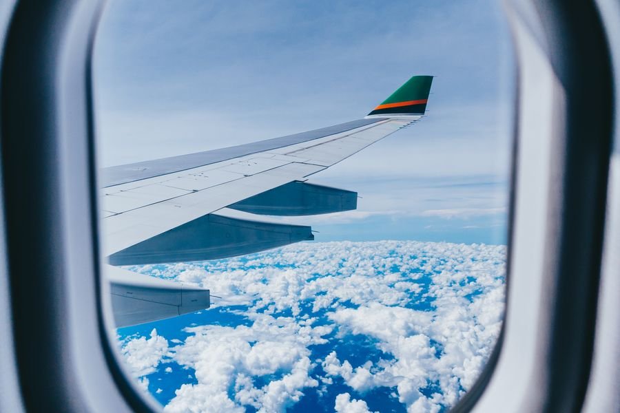 Vista del ala del avión desde la ventanilla sobre las nubes, la recompensa de acumular millas volando
