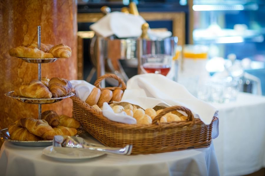 Desayuno buffet con panes y croissants dentro de un club de cadena hotelera