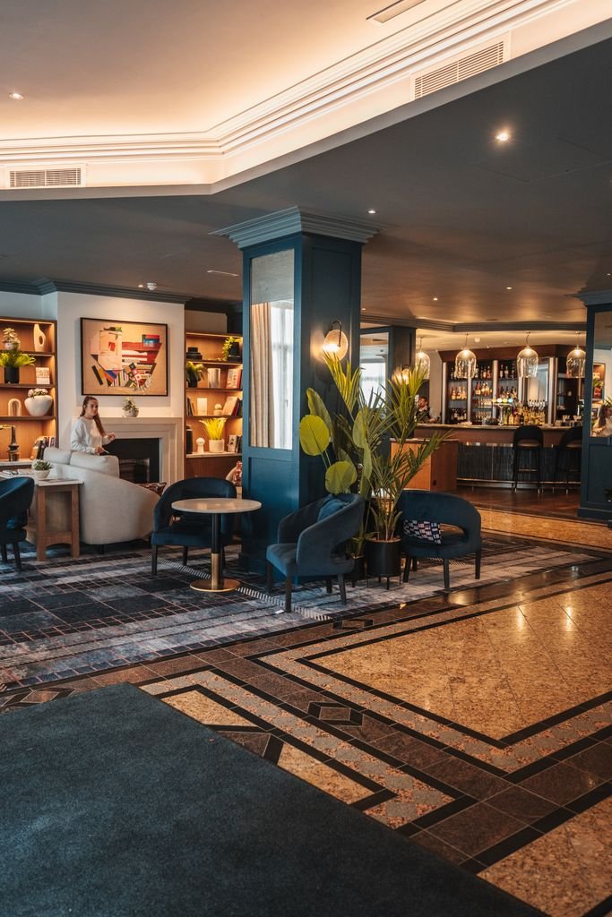 Lounge ejecutivo de un club de cadena hotelera con bar y sillones elegantes