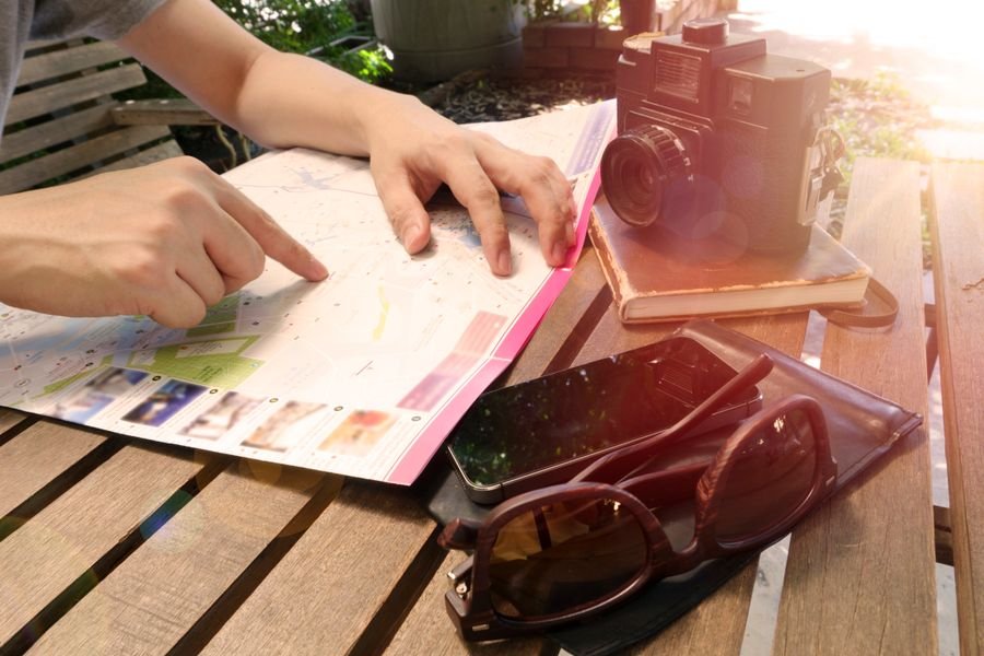 Persona planeando su viaje señalando un mapa antes de pasarlo a mapas personalizados en Google
