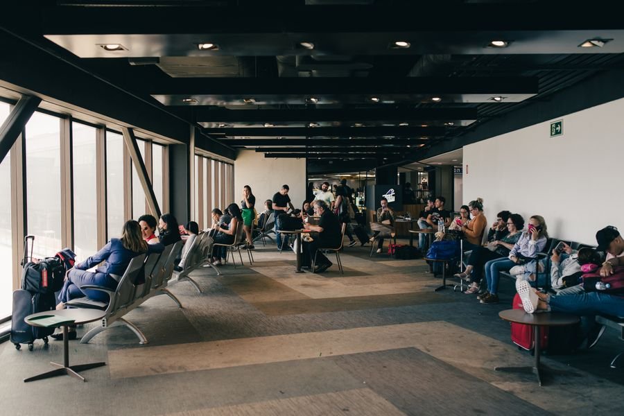 viajeros en la sala de espera del aeropuerto eligiendo su programa de viajero frecuente