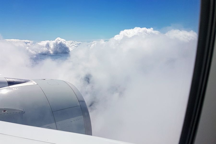 volar en primera clase con AMEX Platinum - motor del avión entre las nubes