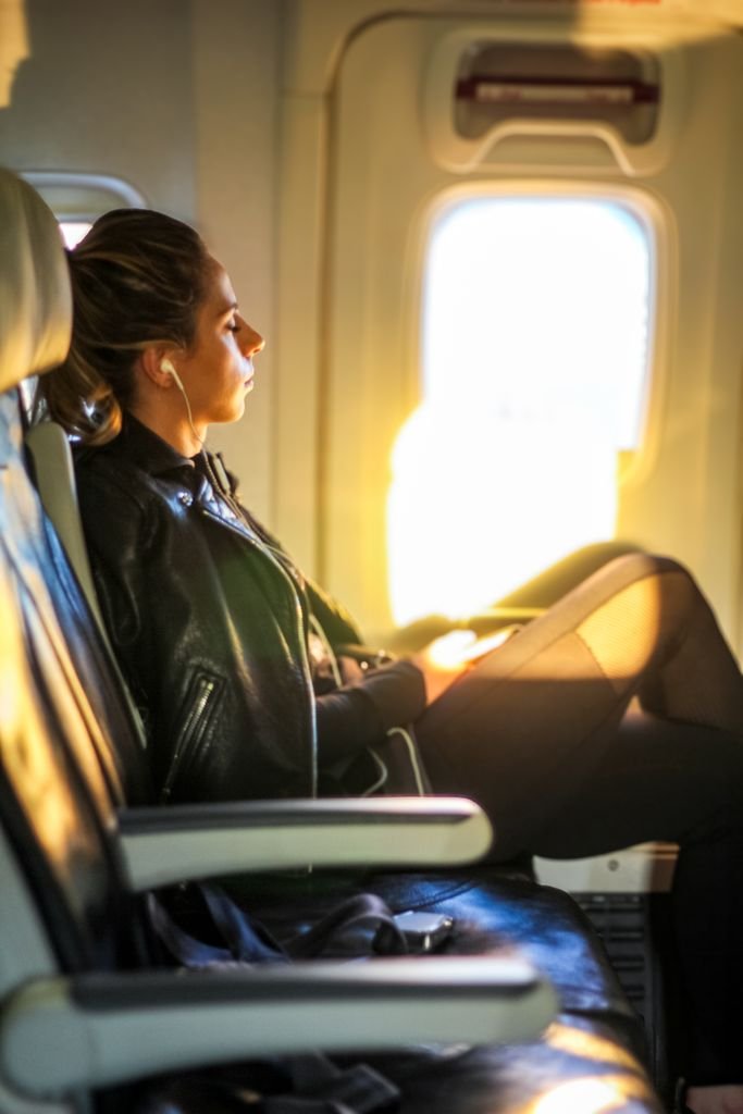 Viajera descansando junto a la ventanilla al volar a Japón con puntos