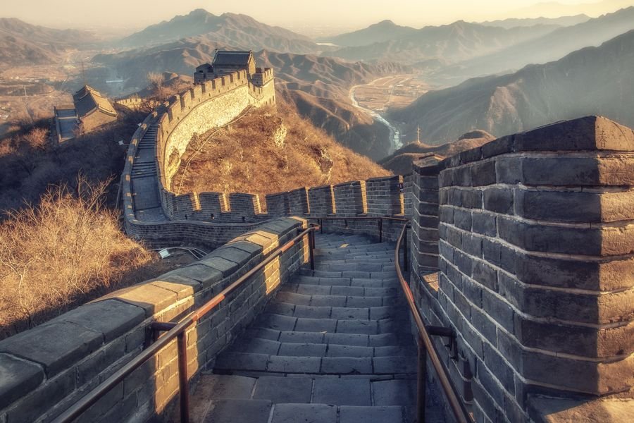 volar a China con puntos - la Gran Muralla China entre montañas al atardecer